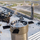The Super Heavy Booster 7 prototype at the launch mount, with Starship 24 upper stage in the background.